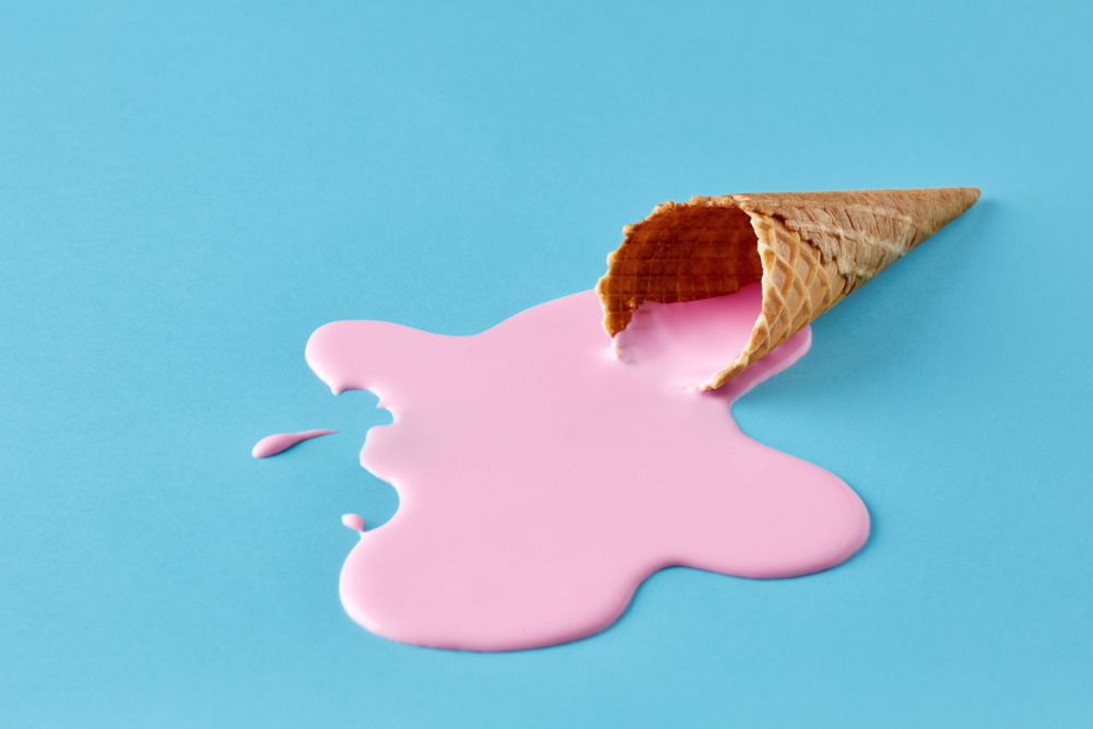 melted strawberry ice cream cone on a blue background